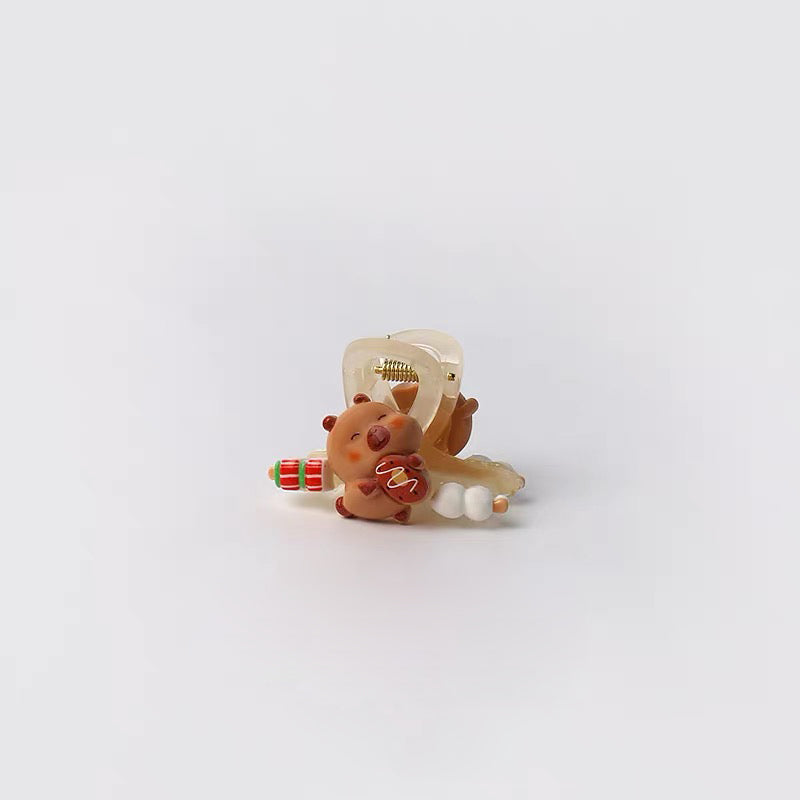 Small decorative item resembling a bear with a bow and gift on a white background