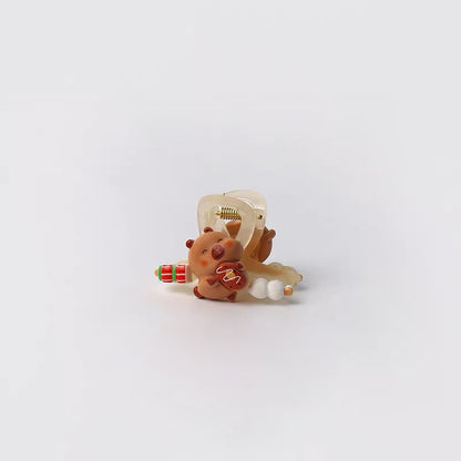 Small decorative item resembling a bear with a bow and gift on a white background