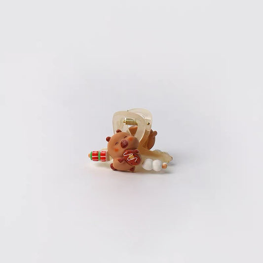 Small decorative item resembling a bear with a bow and gift on a white background